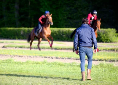 entraineur et chevaux au galop piste entrainement