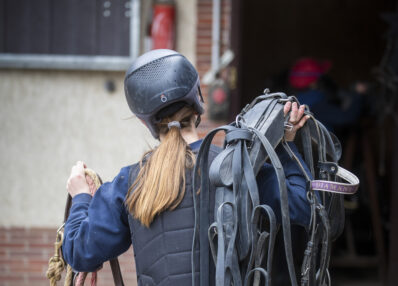 ETUDIANTE QUI PORTE DU MATERIEL ECURIE