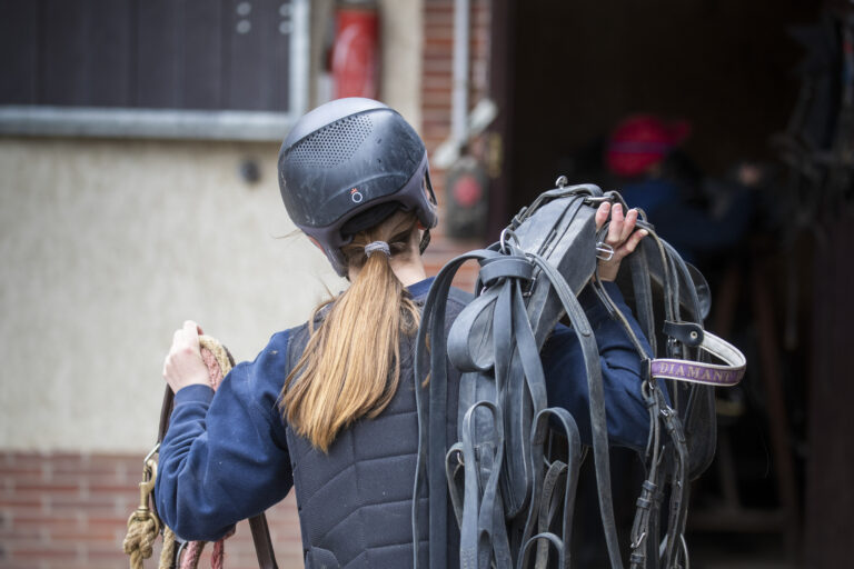 ETUDIANTE QUI PORTE DU MATERIEL ECURIE
